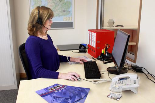 An STS employee works at her desk in the manual handling equipment manufacturer's sales office.