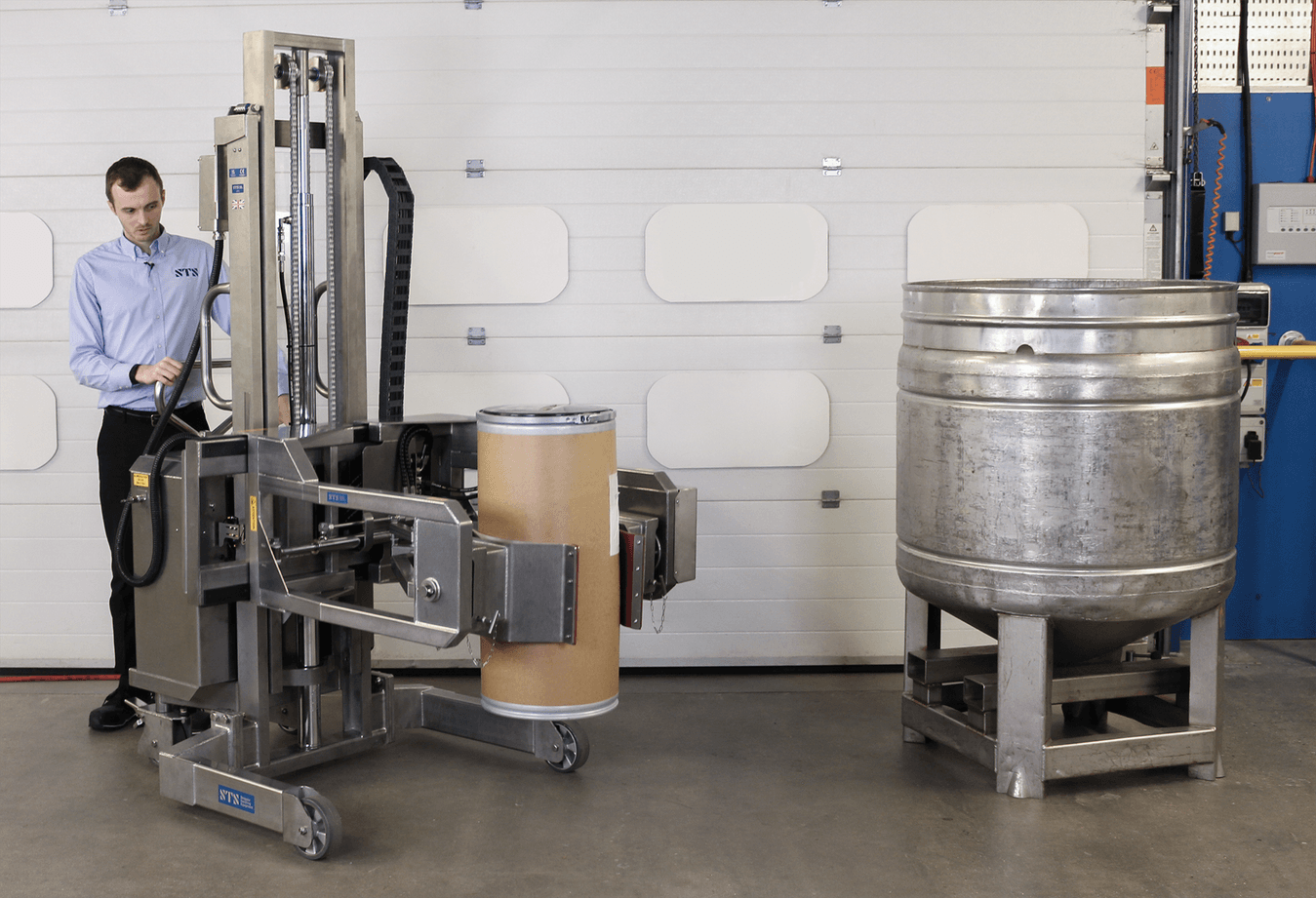 A fibreboard drum being lifted, prior to being emptied into a stainless steel vessel.