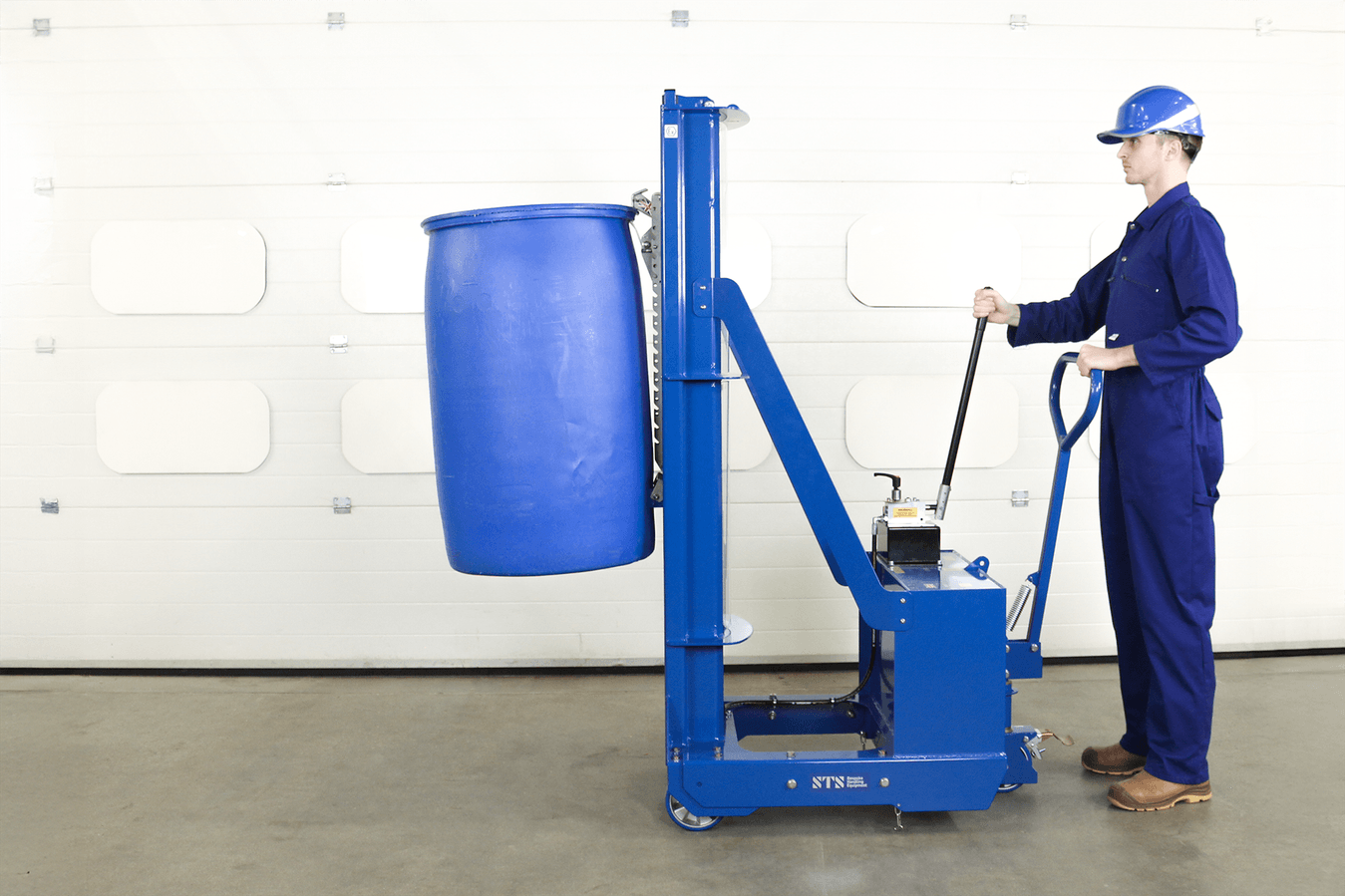 Factory worker operating a manual hydraulic drum lifter, lifting an L-Ring plastic drum.