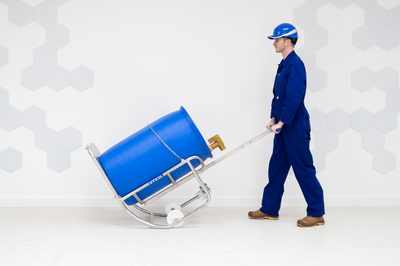 The engineer tips a 200L steel drum using the STS drum dispenser.