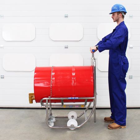 An operator uses an STS drum dispenser and drum cradle for material handling