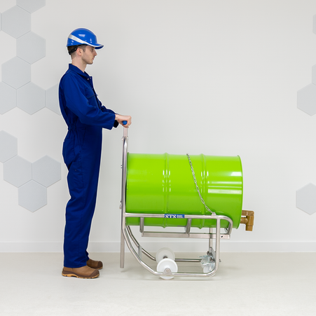 An operator uses an STS drum dispenser and drum cradle for material handling
