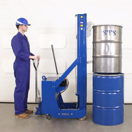 Operator uses the drum stacker to load a steel open-top drum vertically on top of another drum.