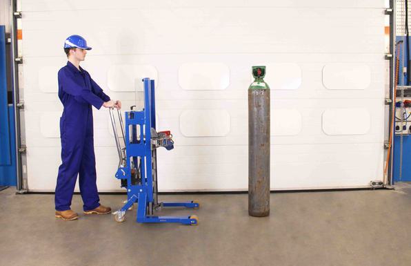 Operator approaches a gas bottle with a cylinder lifter.