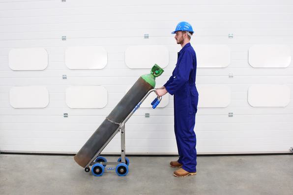 An operator using the STS Gas Cylinder Trolley to transport gas cylinders